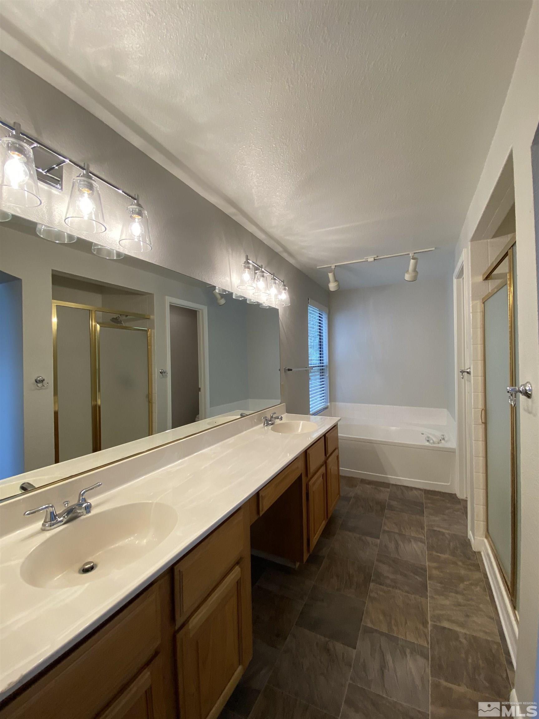 1562 Bramble Court Reno, NV 89509 - Photo 15 of 22 a bathroom with a tub sink and mirror