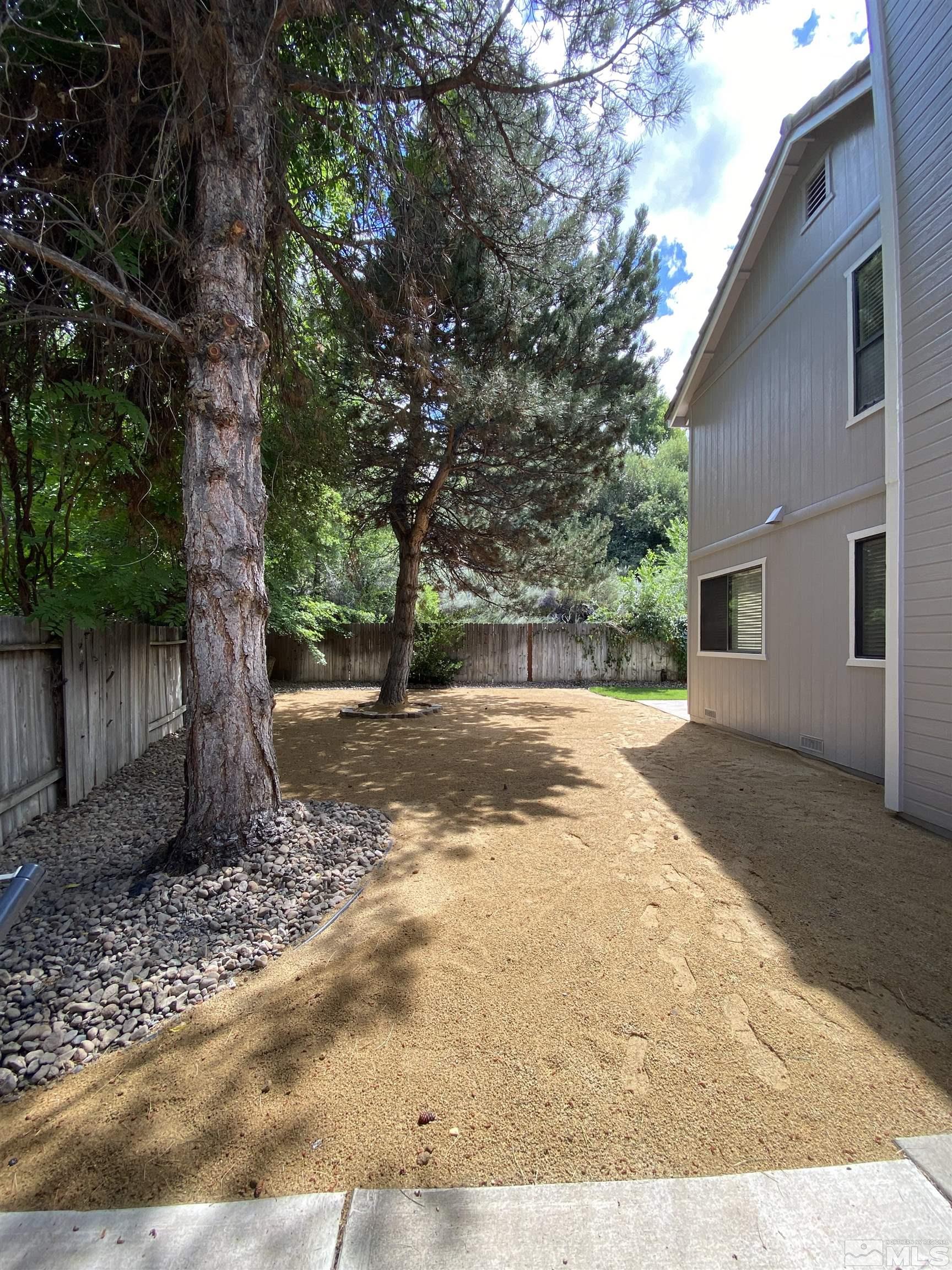 1562 Bramble Court Reno, NV 89509 - Photo 22 of 22 a view of a backyard with large trees and wooden fence