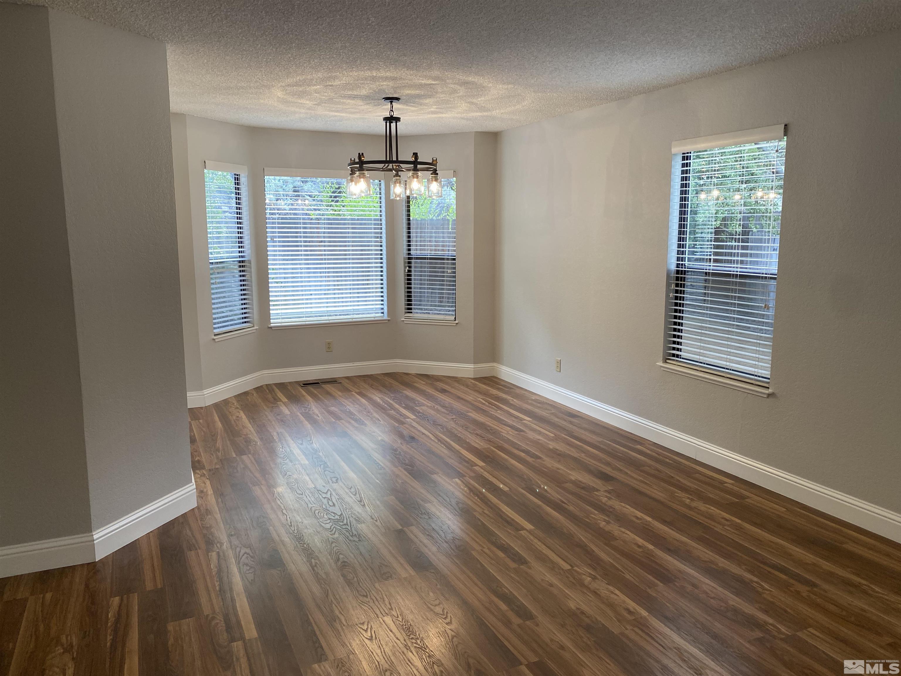 1562 Bramble Court Reno, NV 89509 - Photo 4 of 22 a view of an empty room with wooden floor and a window