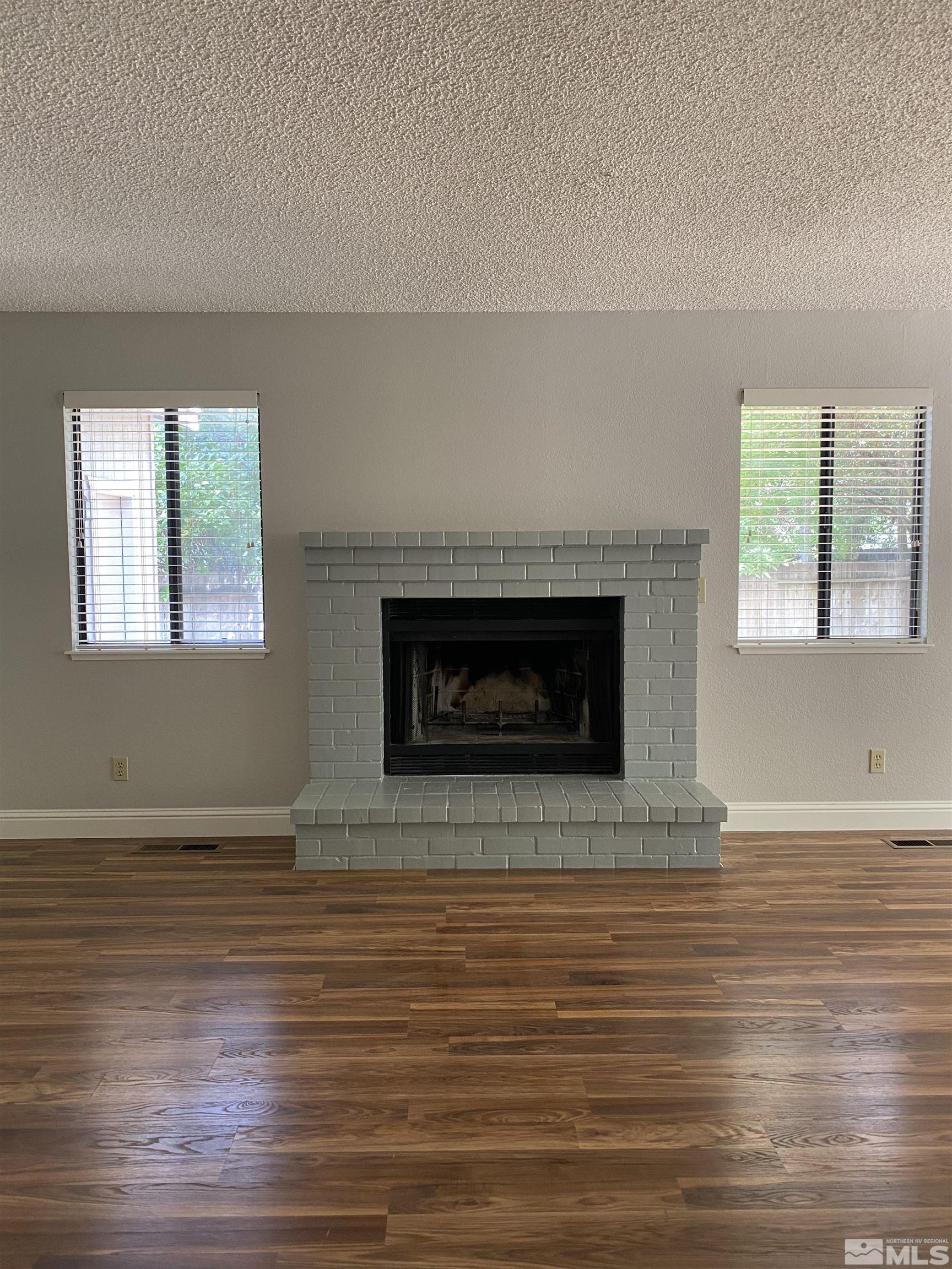 1562 Bramble Court Reno, NV 89509 - Photo 5 of 22 a view of an empty room with wooden floor and a fireplace