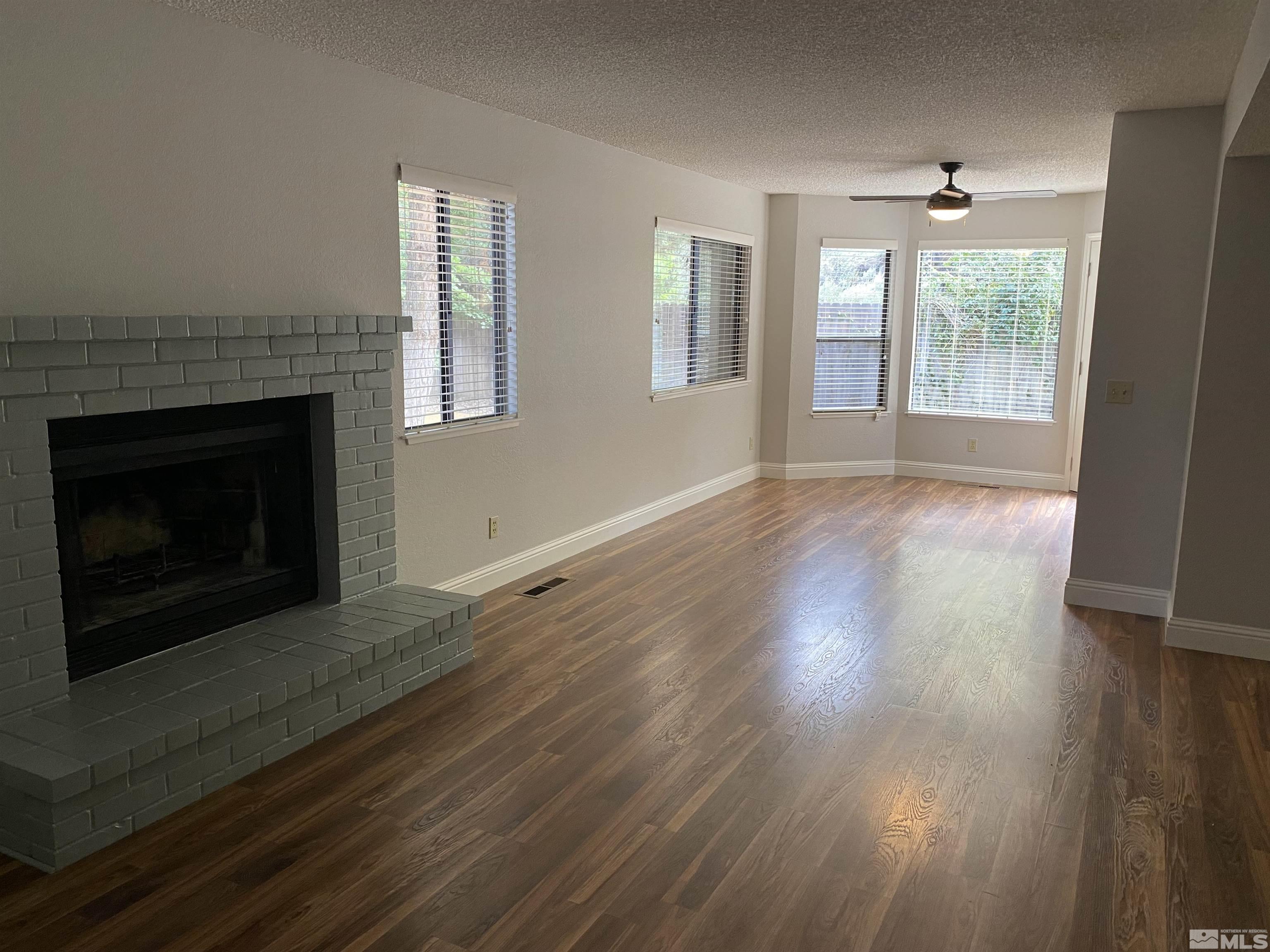 1562 Bramble Court Reno, NV 89509 - Photo 6 of 22 a view of an empty room with wooden floor fireplace and a window