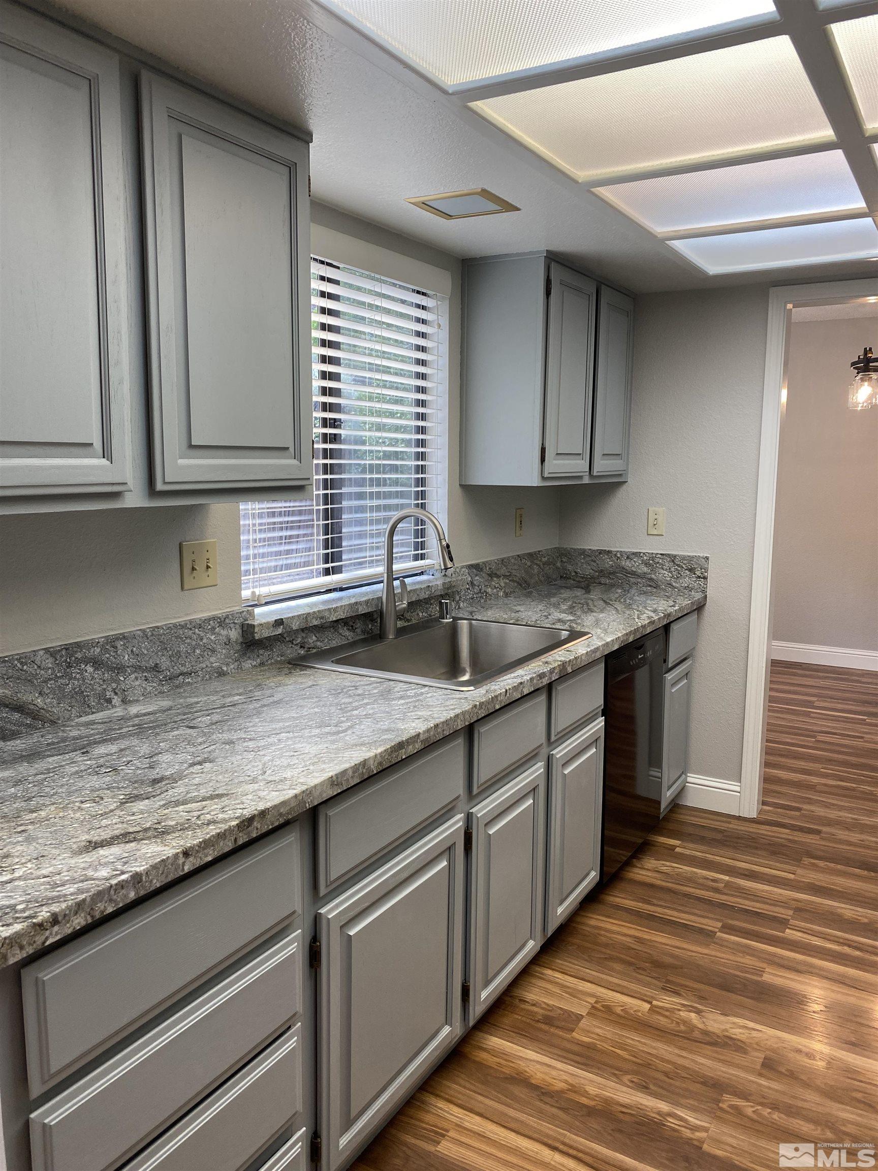 1562 Bramble Court Reno, NV 89509 - Photo 8 of 22 a kitchen with granite countertop a sink a stove and cabinets