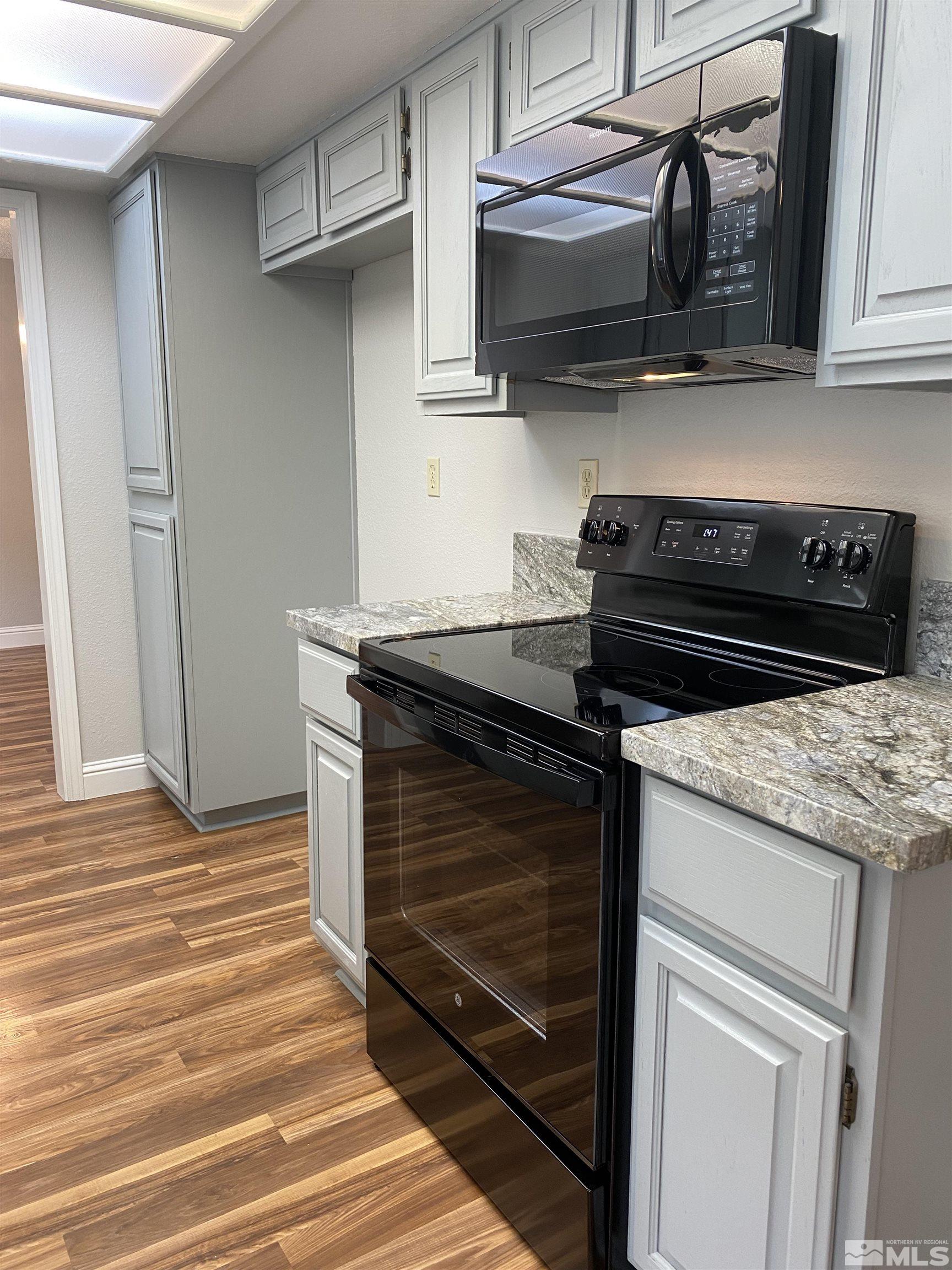1562 Bramble Court Reno, NV 89509 - Photo 9 of 22 a kitchen with stainless steel appliances granite countertop a stove and a microwave