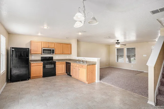 a kitchen with stainless steel appliances granite countertop a refrigerator and a sink
