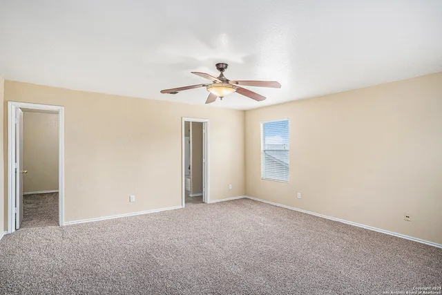 a view of an empty room with a ceiling fan