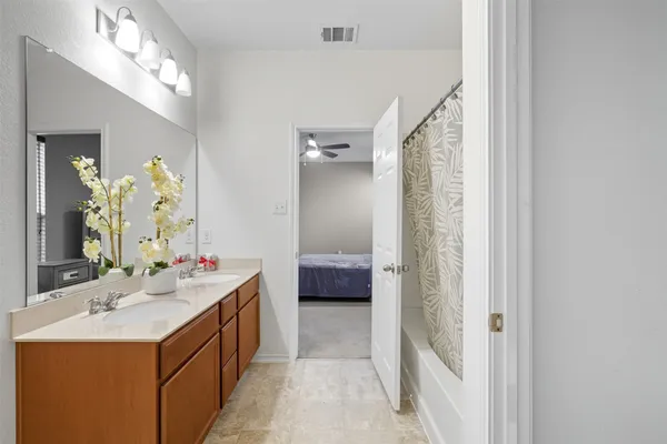 a en suite bathroom with a double vanity sink a mirror and a shower