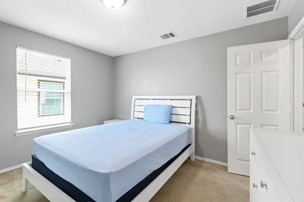 a bedroom with a bed and a window