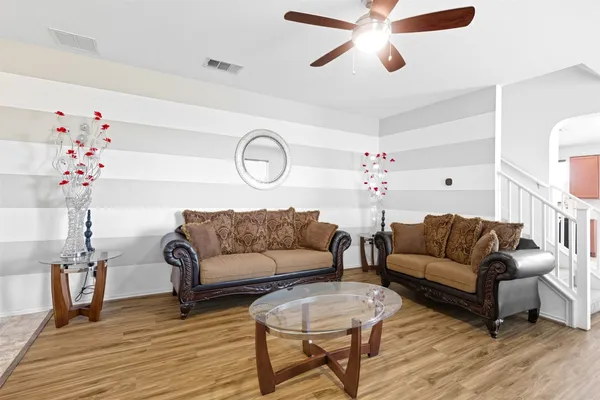 a living room with furniture and a wooden floor
