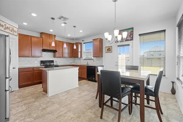 a view of kitchen with dining table chairs sink and cabinets