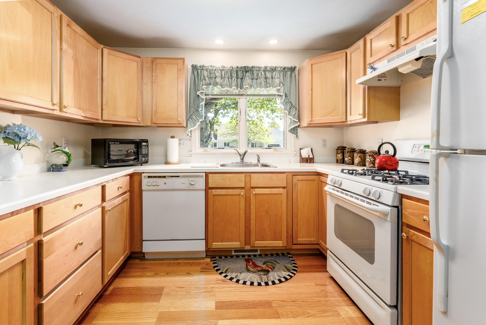 7 Masters Court Mashpee, MA 02649 - Photo 8 of 34 a kitchen with stainless steel appliances granite countertop a sink a stove cabinets and a window