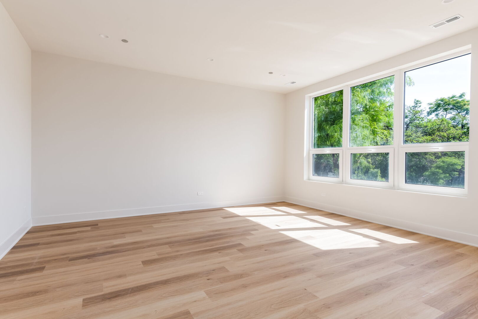 224 South Ashland Avenue, Unit 303 Chicago, IL 60607 - Photo 9 of 18 a view of an empty room with wooden floor and a window