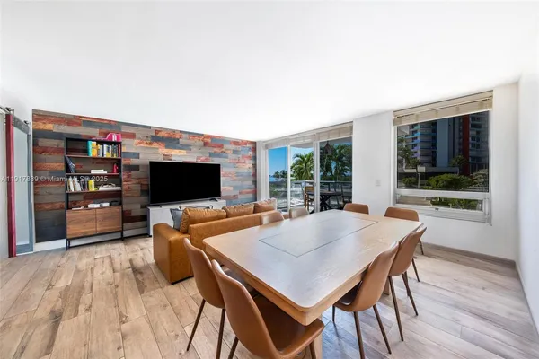 a living room with furniture a flat screen tv and a floor to ceiling window