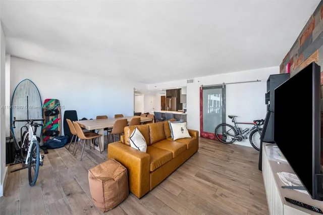 a living room with furniture a flat screen tv and a table