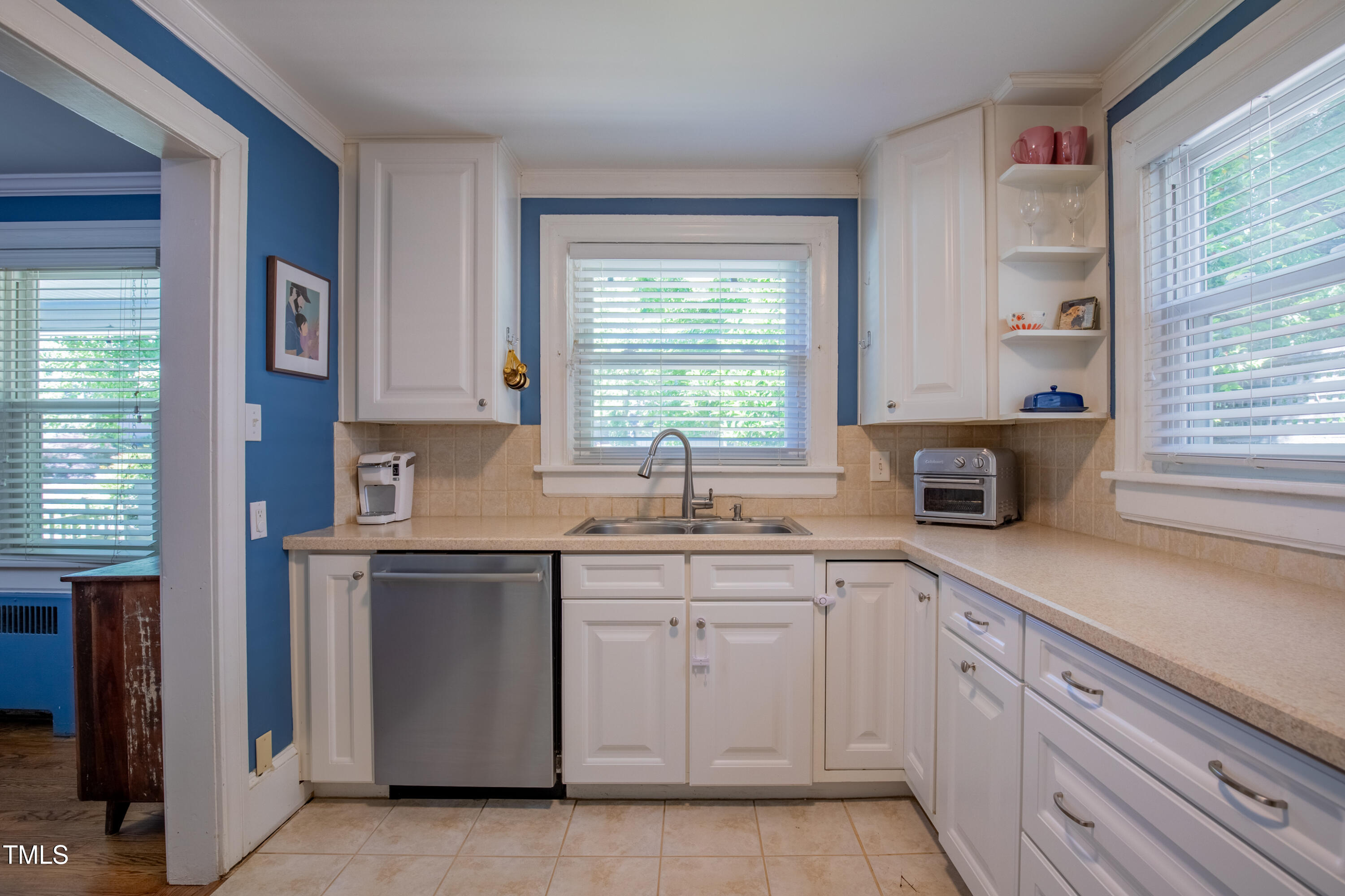 1714 Carson Street Raleigh, NC 27608 - Photo 16 of 38 a kitchen with white cabinets and a window