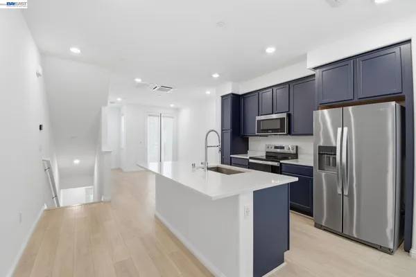 a kitchen with refrigerator a sink a stove a microwave and cabinets