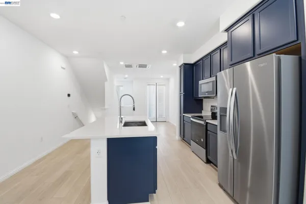 a kitchen with refrigerator a sink and cabinets