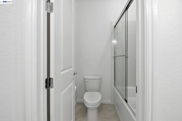 a white toilet sitting next to a small bathroom