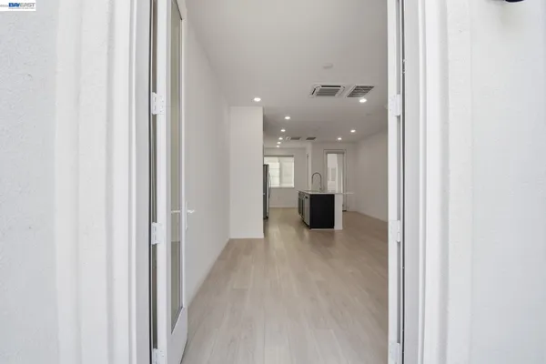 a view of a hallway with a kitchen space and a sink