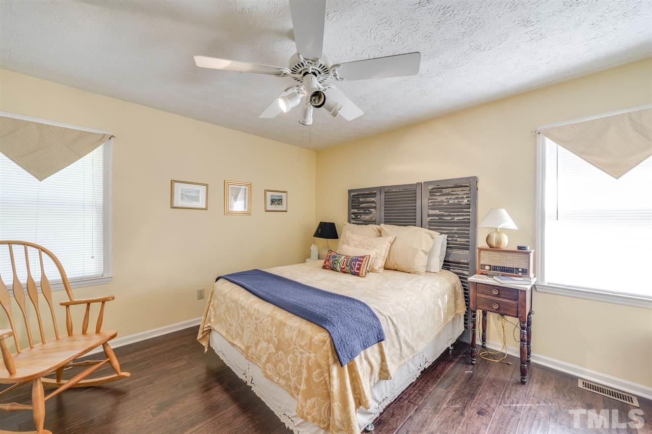 167 Hidden Hills Road Roxboro, NC 27574 - Photo 17 of 25 a bedroom with a bed and a chandelier