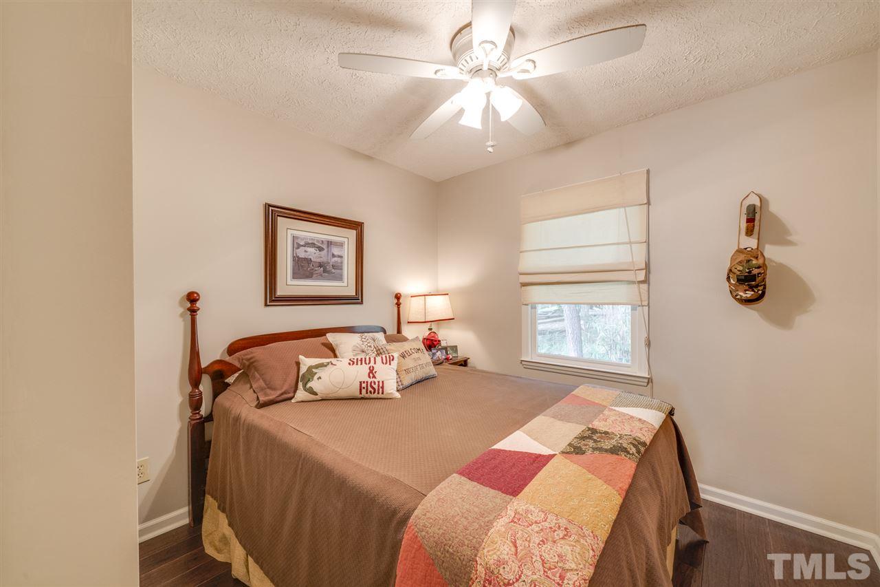 167 Hidden Hills Road Roxboro, NC 27574 - Photo 18 of 25 a bedroom with a bed and a chandelier