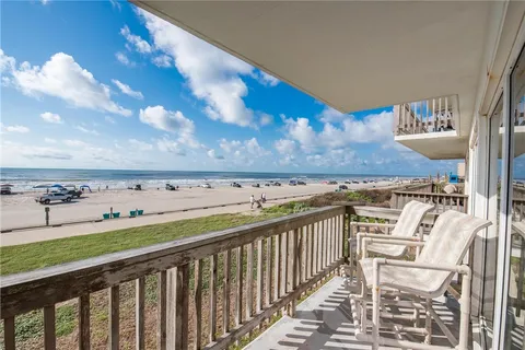 a view of a yard with an ocean and trees in the background