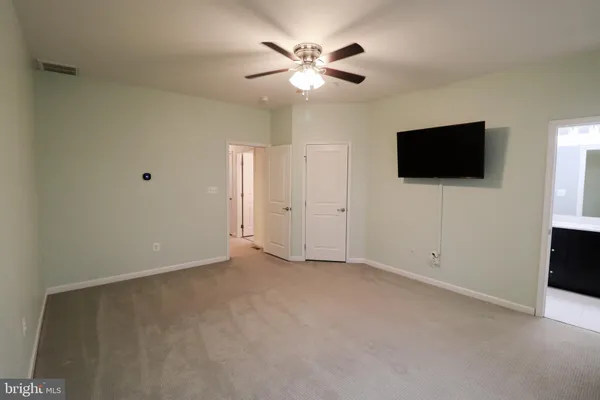 an empty room with window and a ceiling fan