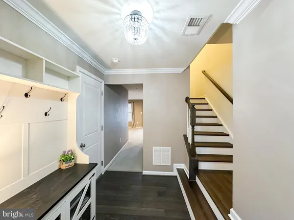 a view of a hallway with entryway and wooden floor