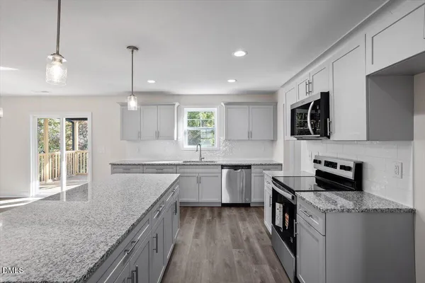 a kitchen with stainless steel appliances granite countertop a sink stove and refrigerator