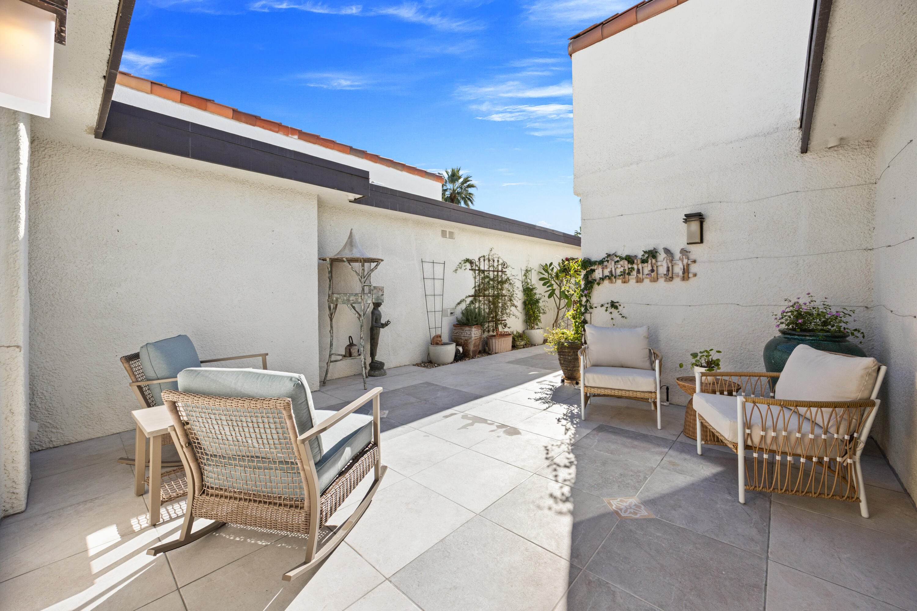 53 Marbella Drive Rancho Mirage, CA 92270 - Photo 31 of 45 a patio with a table and chairs and potted plants