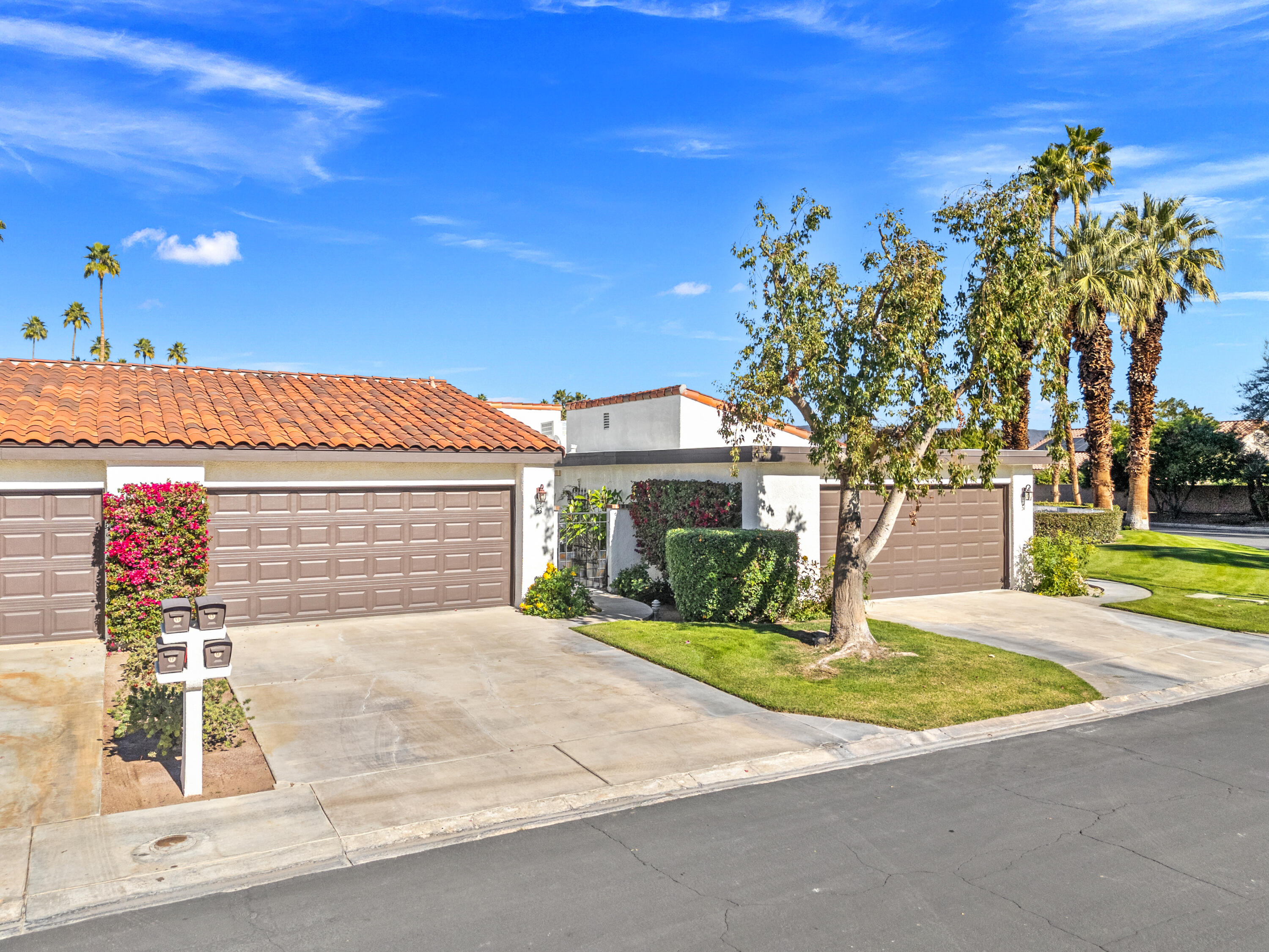 53 Marbella Drive Rancho Mirage, CA 92270 - Photo 35 of 45 a front view of a house with a garden and yard