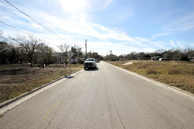 a view of a dry yard with wooden fence