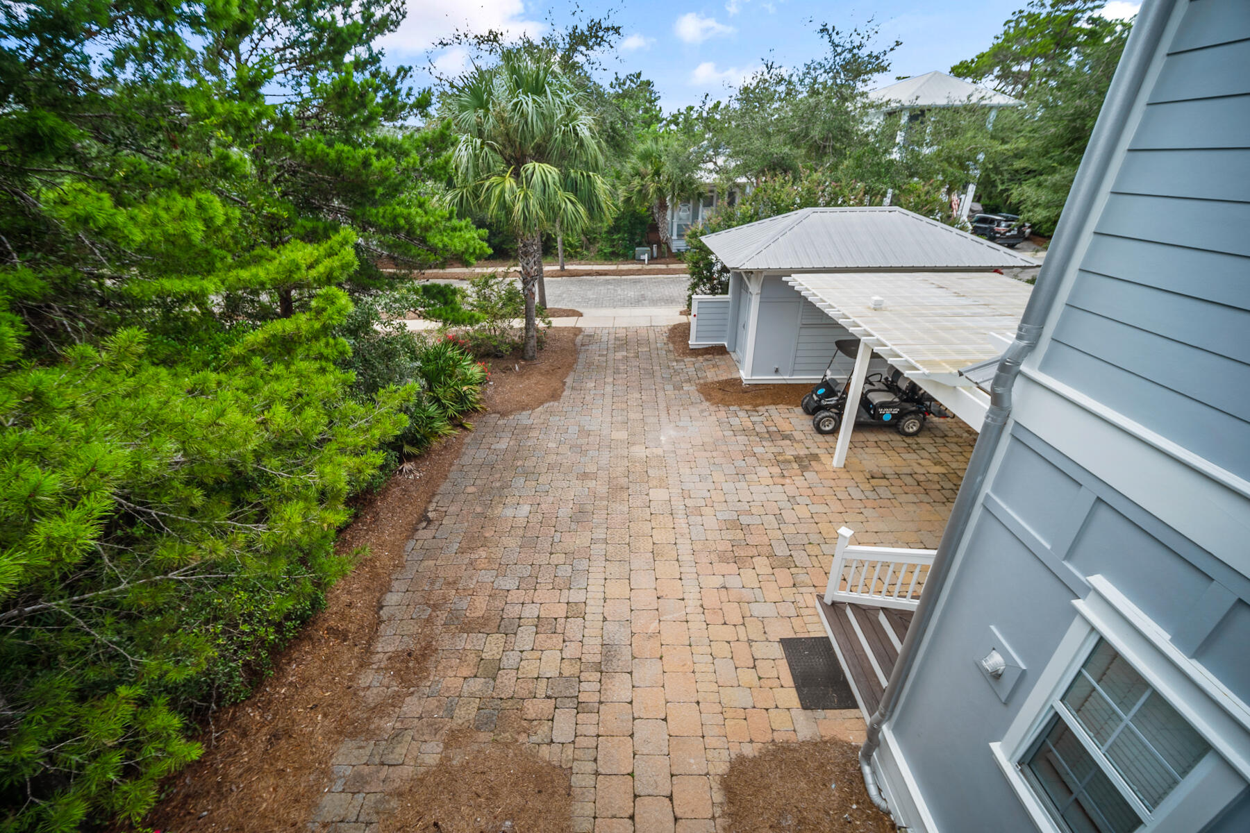 56 Dune Ridge Road Santa Rosa Beach, FL 32459 - Photo 4 of 65 a view of a patio with table and chairs under an umbrella with wooden fence