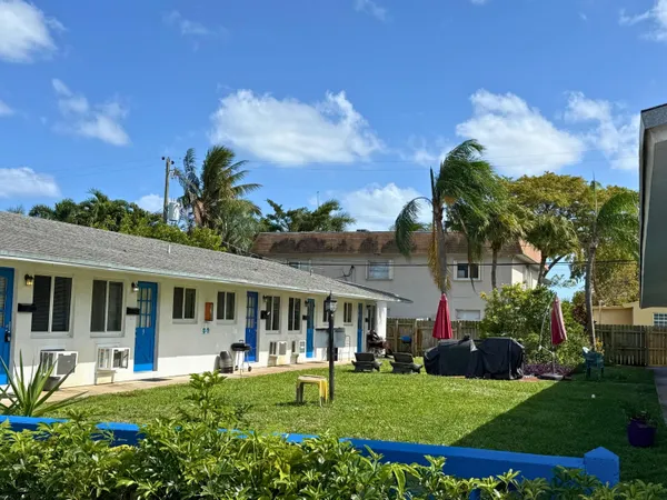a front view of a house with a garden and trees