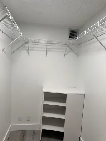 a view of walk in closet with empty racks