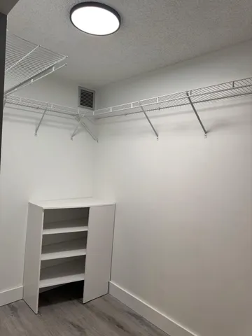 a view of walk in closet with empty racks