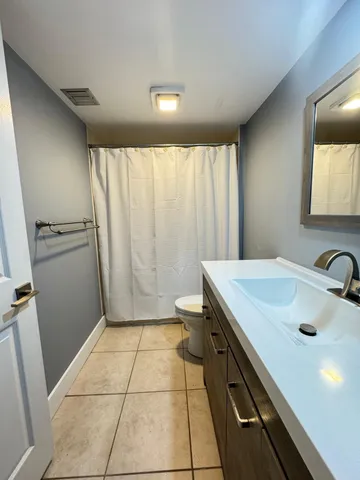 a bathroom with a sink a toilet and a mirror