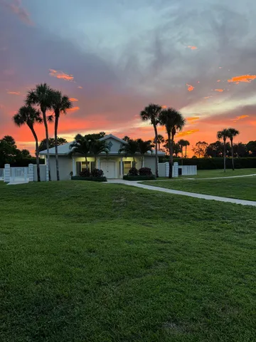 a backyard of a house with lots of green space and fountain