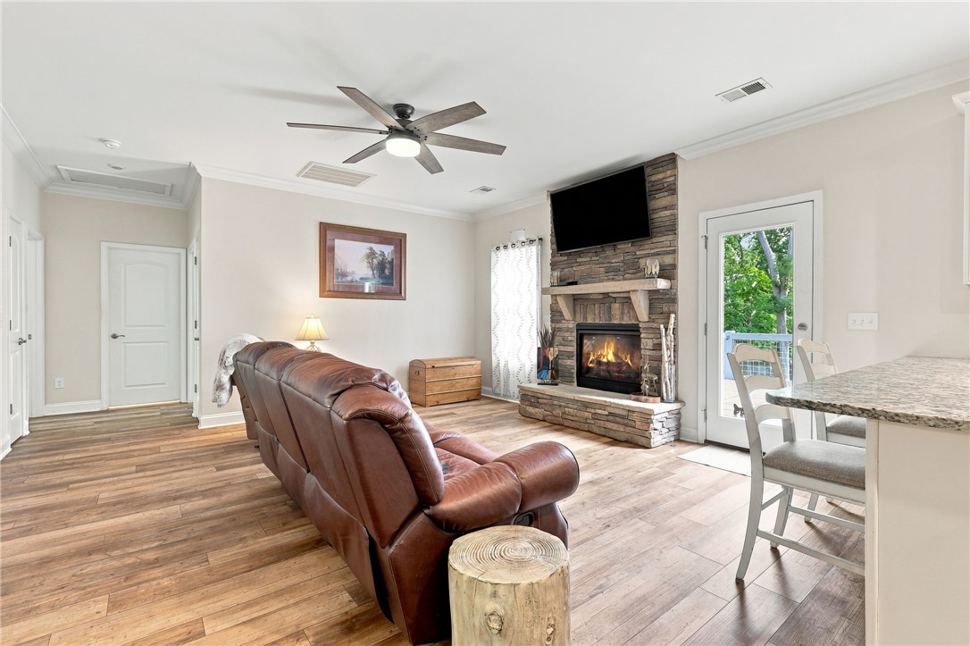 525 Shirley Store Road Anderson, SC 29621 - Photo 13 of 46 Rich wood-look flooring and a stone fireplace define this inviting open living space.