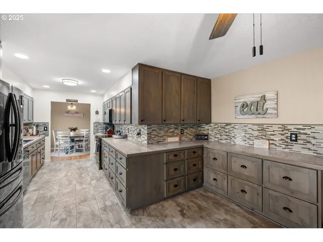 a kitchen with stainless steel appliances kitchen island granite countertop a refrigerator and a stove top oven