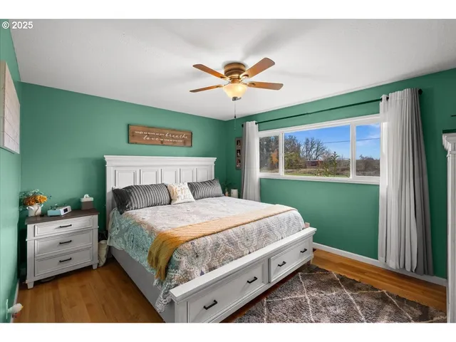 a bedroom with a bed and a painting on the wall