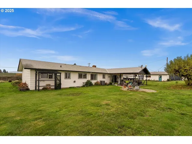 a view of a big house with a big yard and large trees