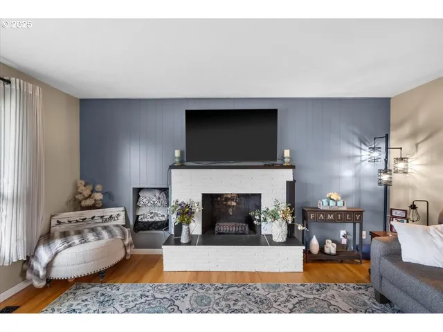 a living room with furniture a flat screen tv and a fireplace