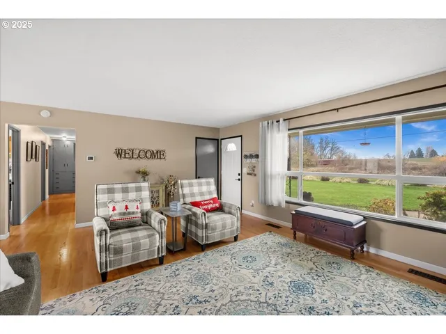 a living room with furniture a flat screen tv and a floor to ceiling window