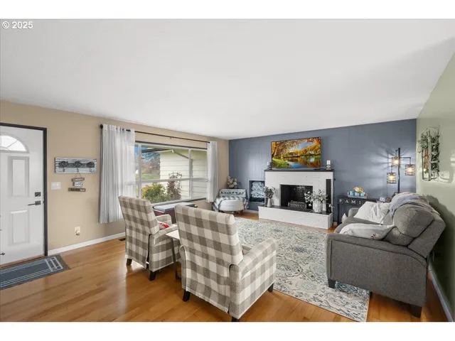 a living room with furniture a fireplace and a large window