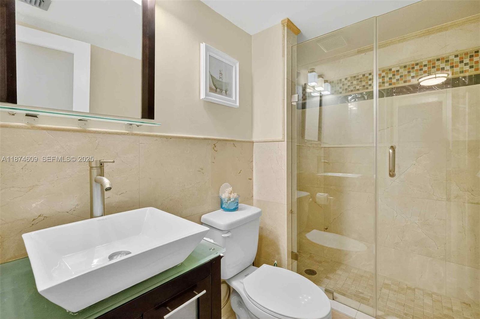 2401 Collins Avenue, Unit 1005 Miami Beach, FL 33140 - Photo 10 of 19 a bathroom with a sink a toilet and shower