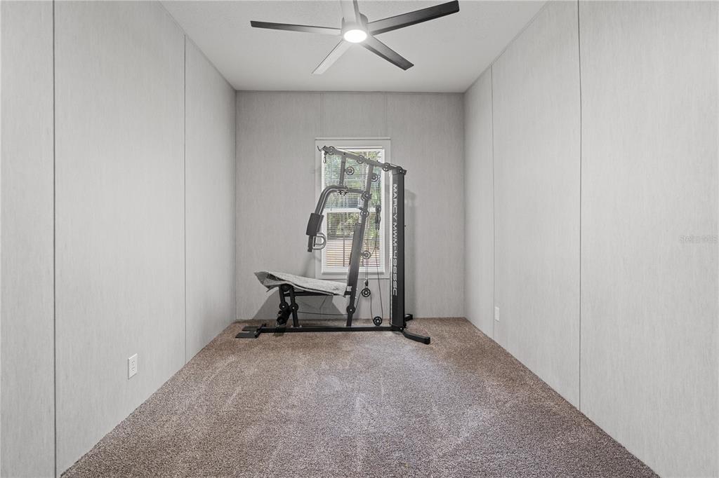375 Sapp Street Inglis, FL 34449 - Photo 27 of 36 an empty room with a mirror and a ceiling fan