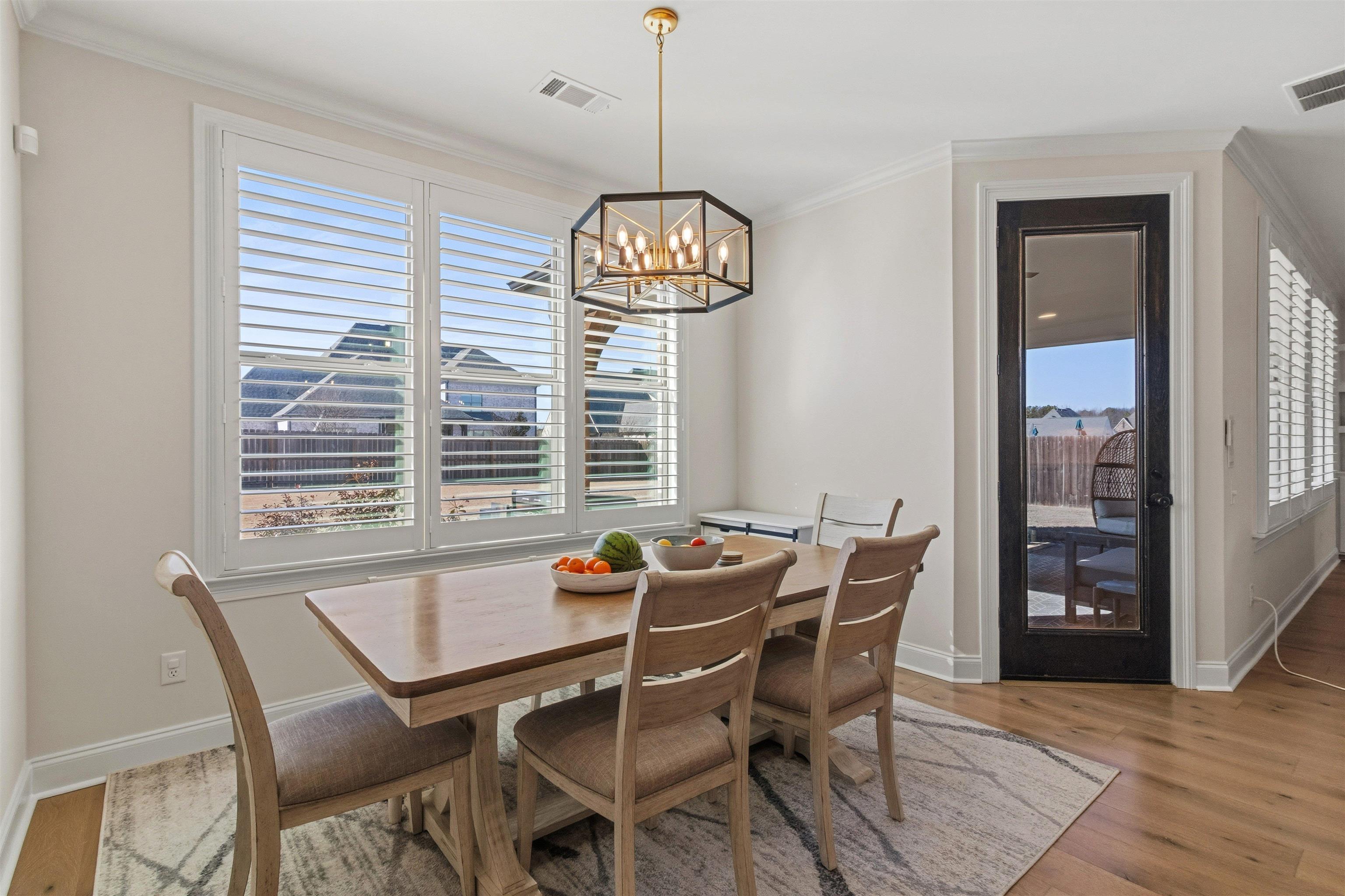 4757 Carousel Lane Collierville, TN 38017 - Photo 14 of 39 Dining area featuring light wood-style floors, hanging lights, and ornamental molding