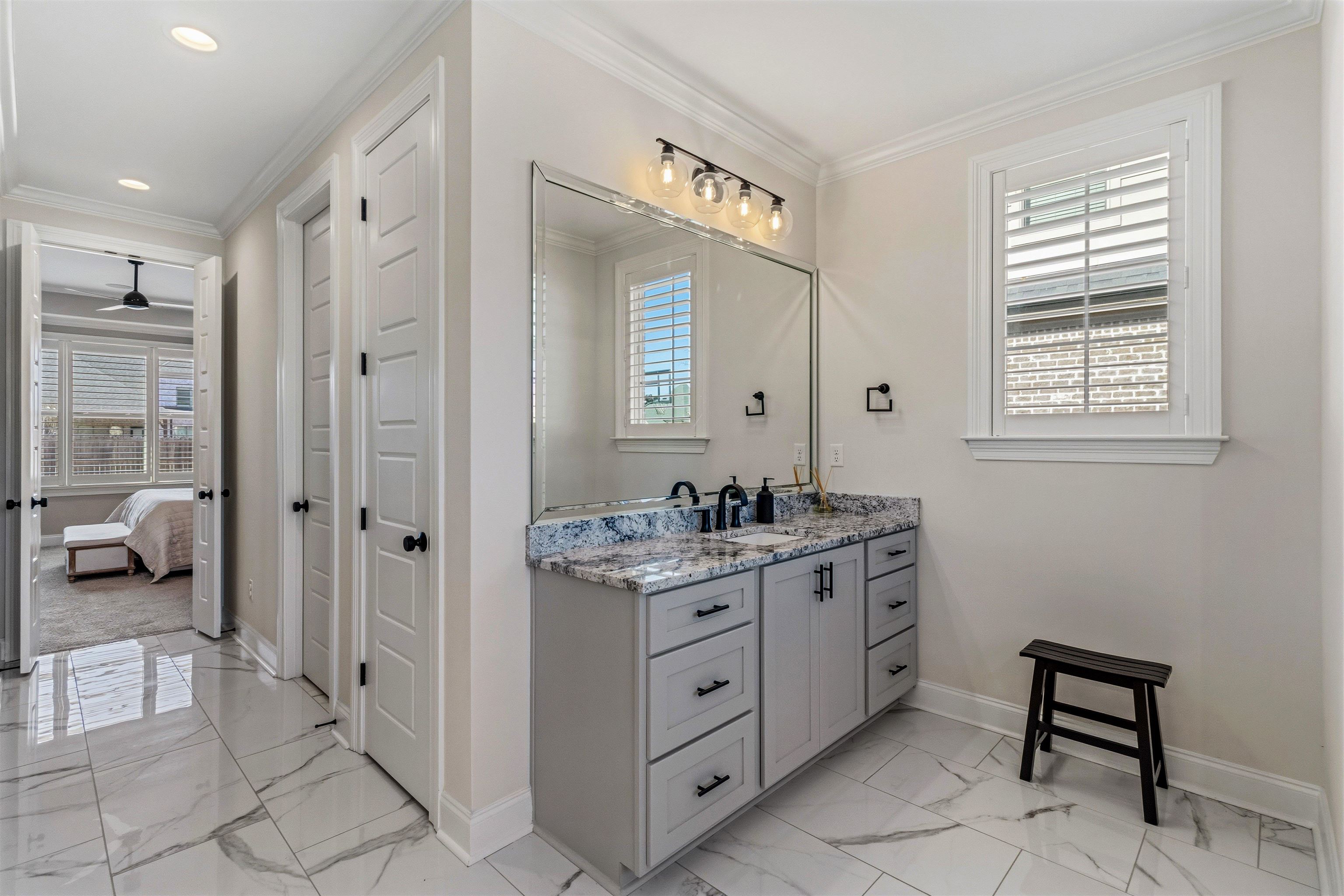 4757 Carousel Lane Collierville, TN 38017 - Photo 20 of 39 Bathroom featuring vanity, ornamental molding, light marble finish flooring, connected bathroom, and a closet