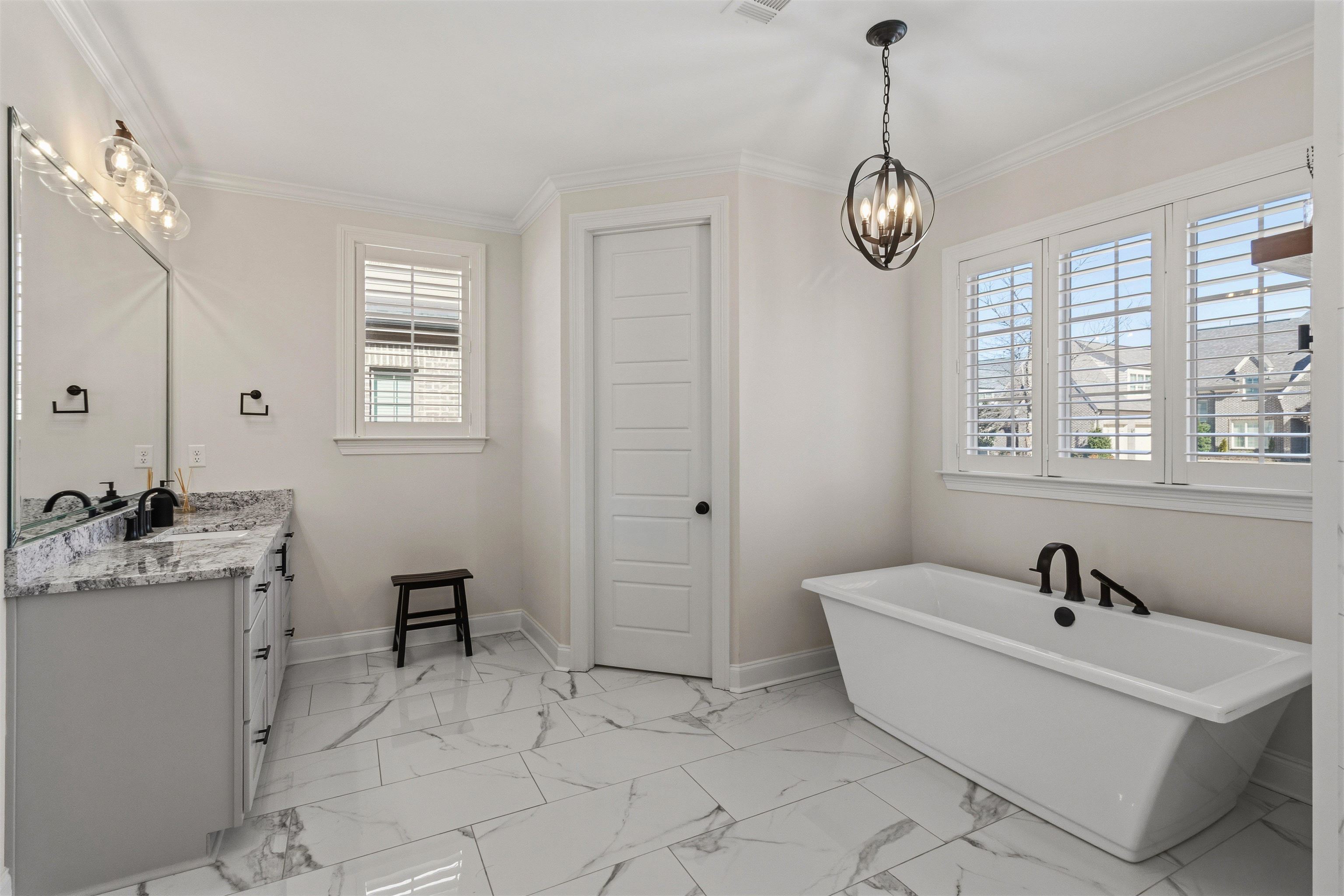 4757 Carousel Lane Collierville, TN 38017 - Photo 21 of 39 Bathroom featuring light marble finish floors, vanity, a freestanding tub, crown molding, and hanging lights