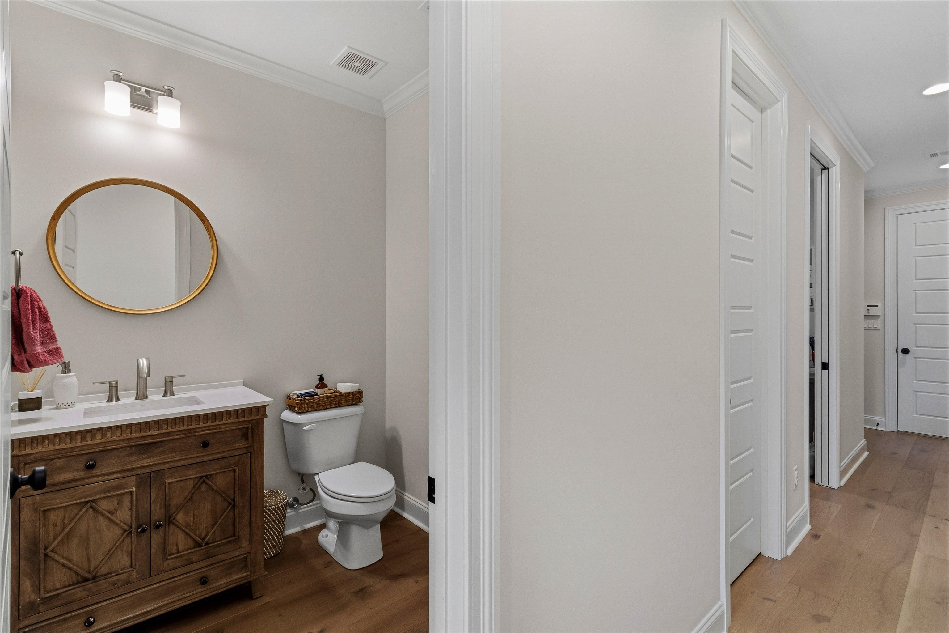 4757 Carousel Lane Collierville, TN 38017 - Photo 23 of 39 Half bathroom with ornamental molding, vanity, and dark wood-style flooring
